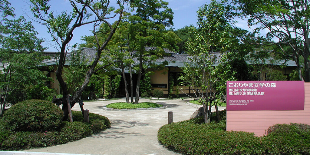 こおりやま文学の森の木に囲まれたエントランスと看板