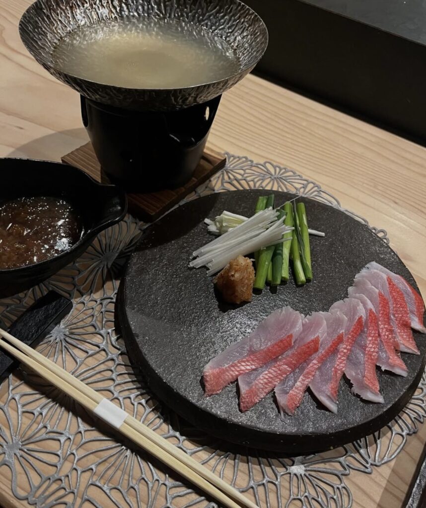 黒いお皿に盛られた赤みの魚のお刺身