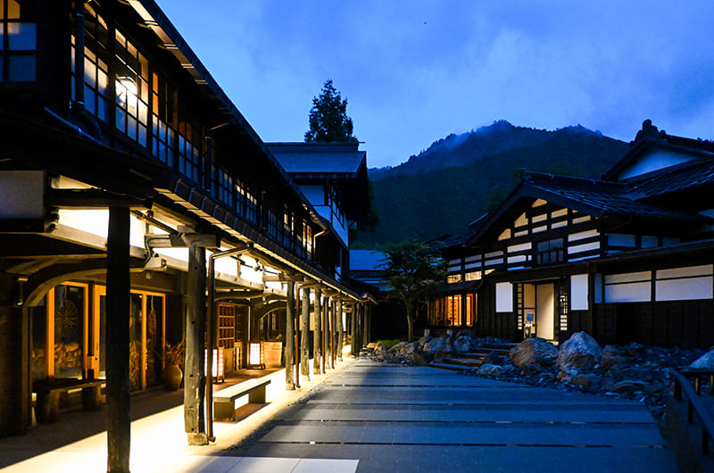 木造屋敷がライトアップされている旅館