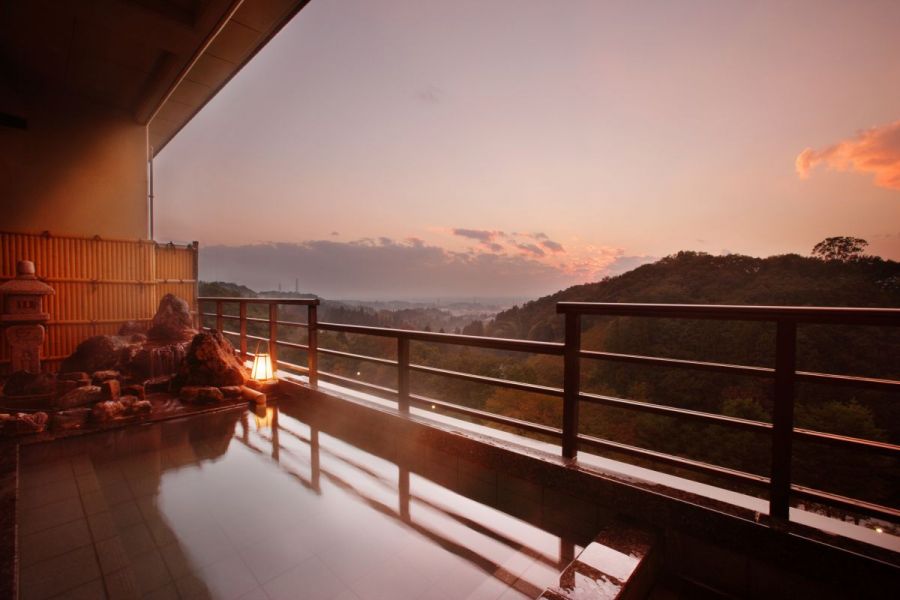 夕焼けで空が赤く染まるとき、露天風呂からあたりを見渡す様子