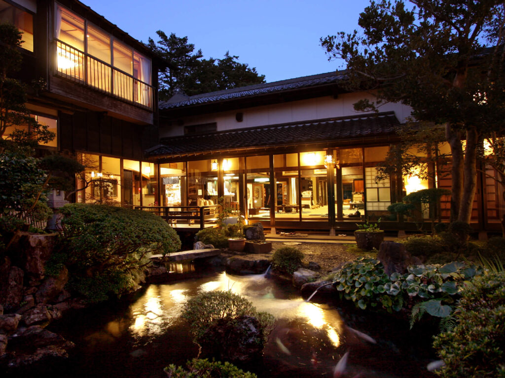 夜に灯りのついた旅館と日本庭園